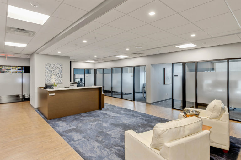 Modern office interior with reception area and glass partition walls for commercial building construction.