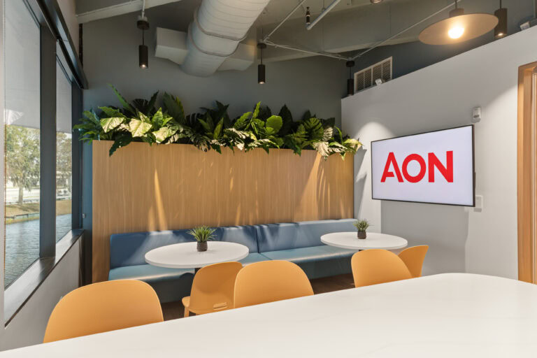 Modern office interior with plants, AON logo, and contemporary furniture from Lay Construction.