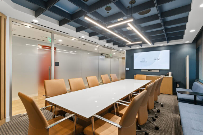 Modern office conference room with glass walls, wooden accents, and state-of-the-art technology for professional meetings.