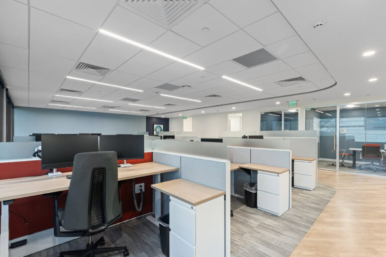 Modern office workspace with cubicles and computer stations for commercial construction projects.