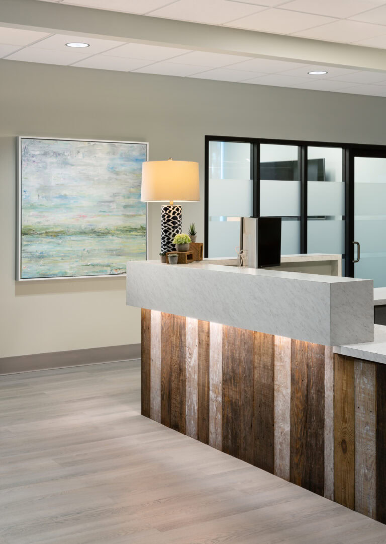 Modern interior reception desk with wood and marble design for commercial office space.