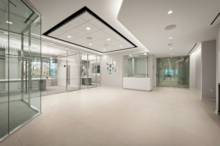 Modern commercial office interior with glass walls and sleek ceiling design, showcasing expert construction by LAY Construction.