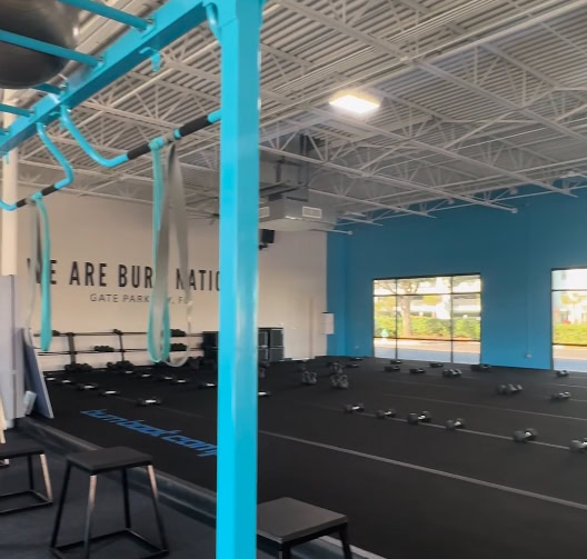 Modern gym interior with workout equipment and blue accents.