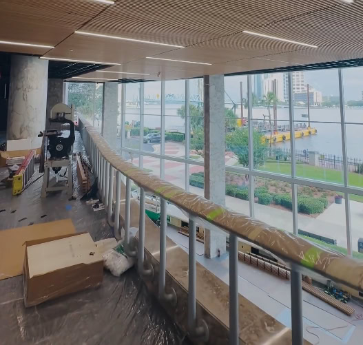 Modern interior construction with large glass windows and safety railing.